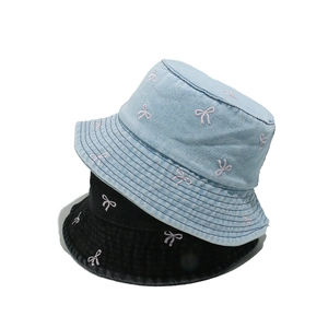 Denim and black bucket hats with pink bow embroidery on a clean white background