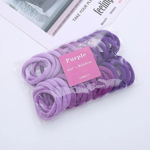 Close-up of purple elastic hair ties in towel fabric texture with rainbow packaging