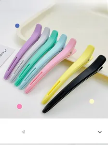 Detail showing seven matte professional sectioning hair clips in assorted pastel colors