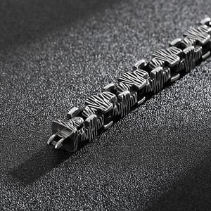 Macro shot of industrial style stainless steel cross bracelet with scratched metal texture