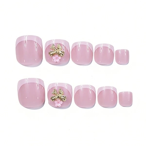 Macro detail of French tip press-on toe nails with pink base and 3D bow decorations