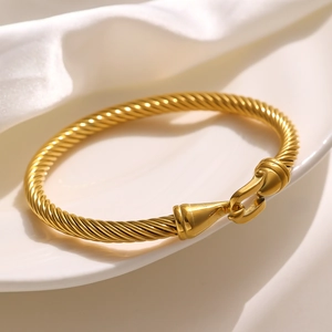 Elegant gold stainless steel cable bracelet with Roman numeral buckle and spiral texture