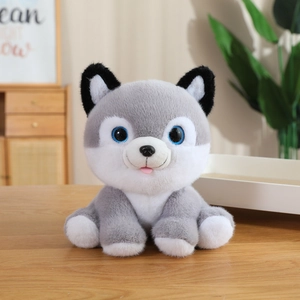 Close-up of a cute husky plush toy with blue eyes and soft grey fur on a wooden table