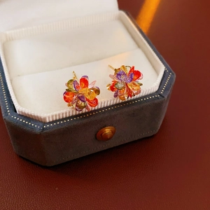 Macro shot of colorful crystal flower stud earrings in a luxury jewelry box