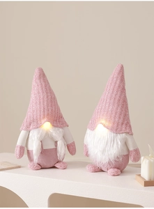 Detail of pink glowing Christmas gnomes with knitted hats and warm LED light noses