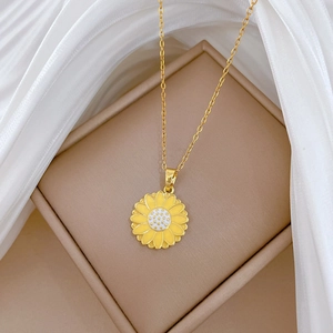 Detail of yellow enamel daisy pendant with crystal accents on a gold titanium steel chain
