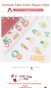 Flat lay of colorful cartoon paper clips in fruit and cactus shapes on a notebook