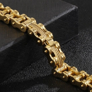Macro view of gold motorcycle chain bracelet with brushed metal texture and link details