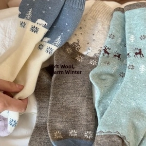 Détail de chaussettes en laine avec motifs d'ours polaire, renne et flocons