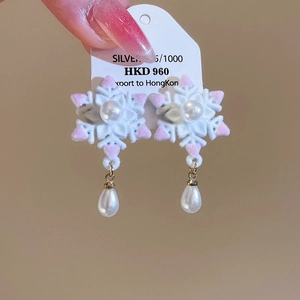 Vue détaillée des boucles d'oreilles flocon de neige avec fourrure et perles nacrées