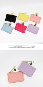 Detailed close-up of quilted coin purses with gold chains and brand logo pendants