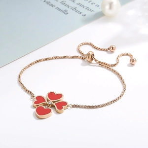 Dettaglio del bracciale a quadrifoglio in oro rosa con quattro cuori rossi e diamante