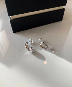 Detailed view of silver twist stud earrings with round cubic zirconia and jewelry box
