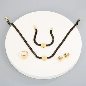 Set di gioielli dorati con pendenti in zircone su un podio bianco rotondo