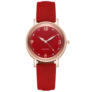 Detailed close-up of a red dial ladies quartz watch with rose gold case and suede strap
