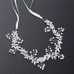 Detail view of silver bridal hair vine with pearls and rhinestones on black background