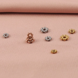 Makroaufnahme von Edelstahl-Schneeflockenperlen in Gold, Silber und Roségold-Optik