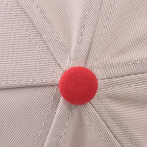 Detailed top view of a color-block baseball cap showing stitching and red crown button