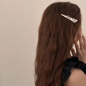 Elegant silver star hair clip with rhinestones worn on brunette wavy hair
