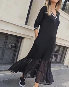 Détail du col en V avec bordure rayée sur une robe midi noire en mesh patchwork
