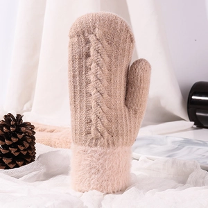 Detail of warm knit mittens in soft beige with thick faux fur cuffs and cable pattern