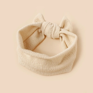 Beige ribbed knit baby headband with a soft bow, elastic hair accessory for infants