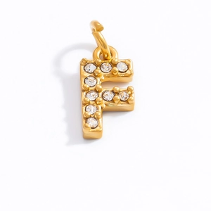 Macro detail of 18K gold plated letter F pendant featuring sparkling crystal inlay