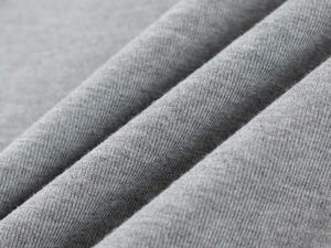 Gros plan détaillé de la texture du tricot gris montrant le tissage fin et la matière douce