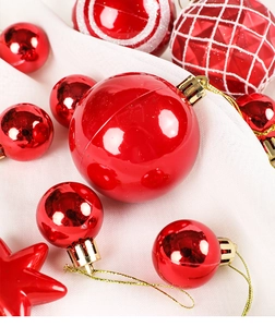 Detail of red Christmas ornaments with shiny and glitter textures on white fabric