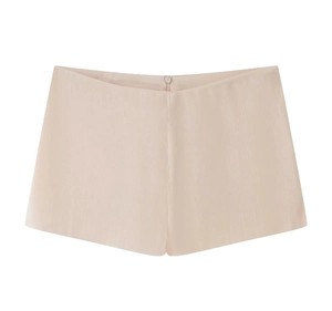 Détail de la texture satinée lisse de couleur champagne sur ce short à volants pour femme
