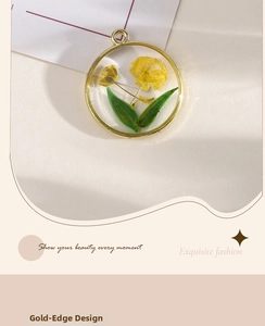 Detailed close-up of handmade resin pendant with real yellow flower and gold frame