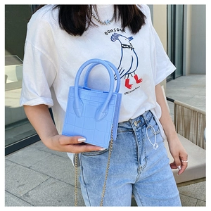 Close-up of light blue crocodile pattern mini square bag with a golden chain strap