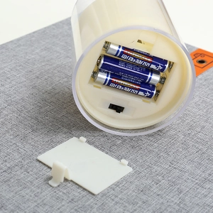 Detailweergave van het batterijvak voor 3 AAA-batterijen van de LED-kaars op linnen