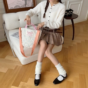 Close-up of beige quilted tote bag with pink straps and adjustable crossbody shoulder strap