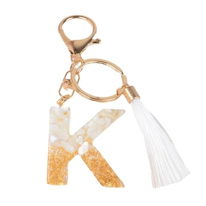 Letter K resin keychain with gold foil, white stones, and elegant silk tassel detail