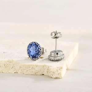 Detail view of oval blue crystal earrings with silver-tone metal backing and butterfly backs