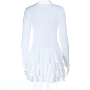 Dettaglio del retro della gonna a balze multistrato di questo abito bianco a maniche lunghe