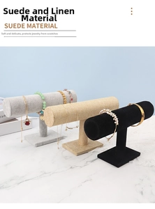 Detail view of T-bar jewelry display stands in velvet and linen textures on marble