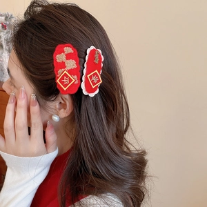 Detail of red Chinese New Year felt hair clips with gold embroidery and lace trim on a model