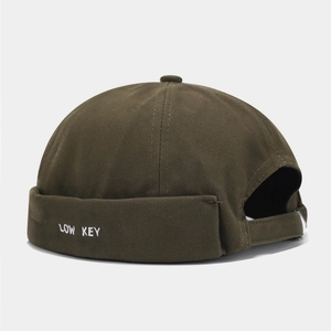Détail de la broderie LOW KEY sur bonnet docker en coton vert olive avec sangle