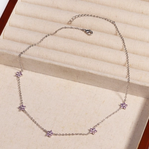 Detailed view of silver necklace with five purple crystal flower pendants in a velvet box