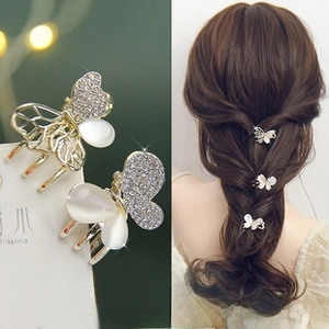 Detail of rhinestone and opal butterfly hair clips with gold metal base for women