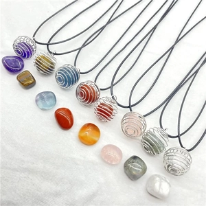 Detailed close-up of varied natural crystal stones in silver spiral cage pendants with cords