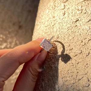 Macro shot of square cut diamond ring showing rainbow fire under natural sunlight