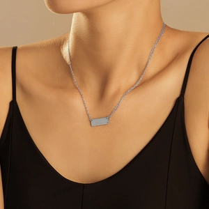 Silver rectangle pendant necklace in titanium steel worn on a model's neck for a minimal look