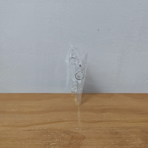 Macro detail of acrylic snowflake ornament with metal ring in transparent packaging