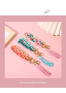 Detailed view of acrylic chain wristlet keychains with vibrant tassels and metal clips