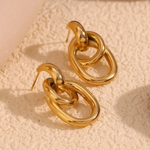 Gros plan sur des boucles d'oreilles ovales entrelacées en acier plaqué or 18 carats