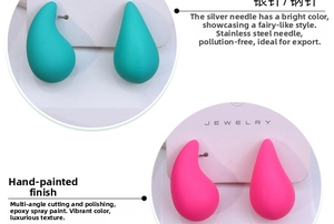 Detailed view of matte water drop earrings with soft-touch paint finish in teal and magenta