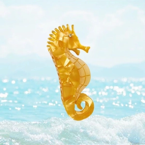 Macro detail of seahorse hair claw made of yellow acetate with sparkling rhinestone eye